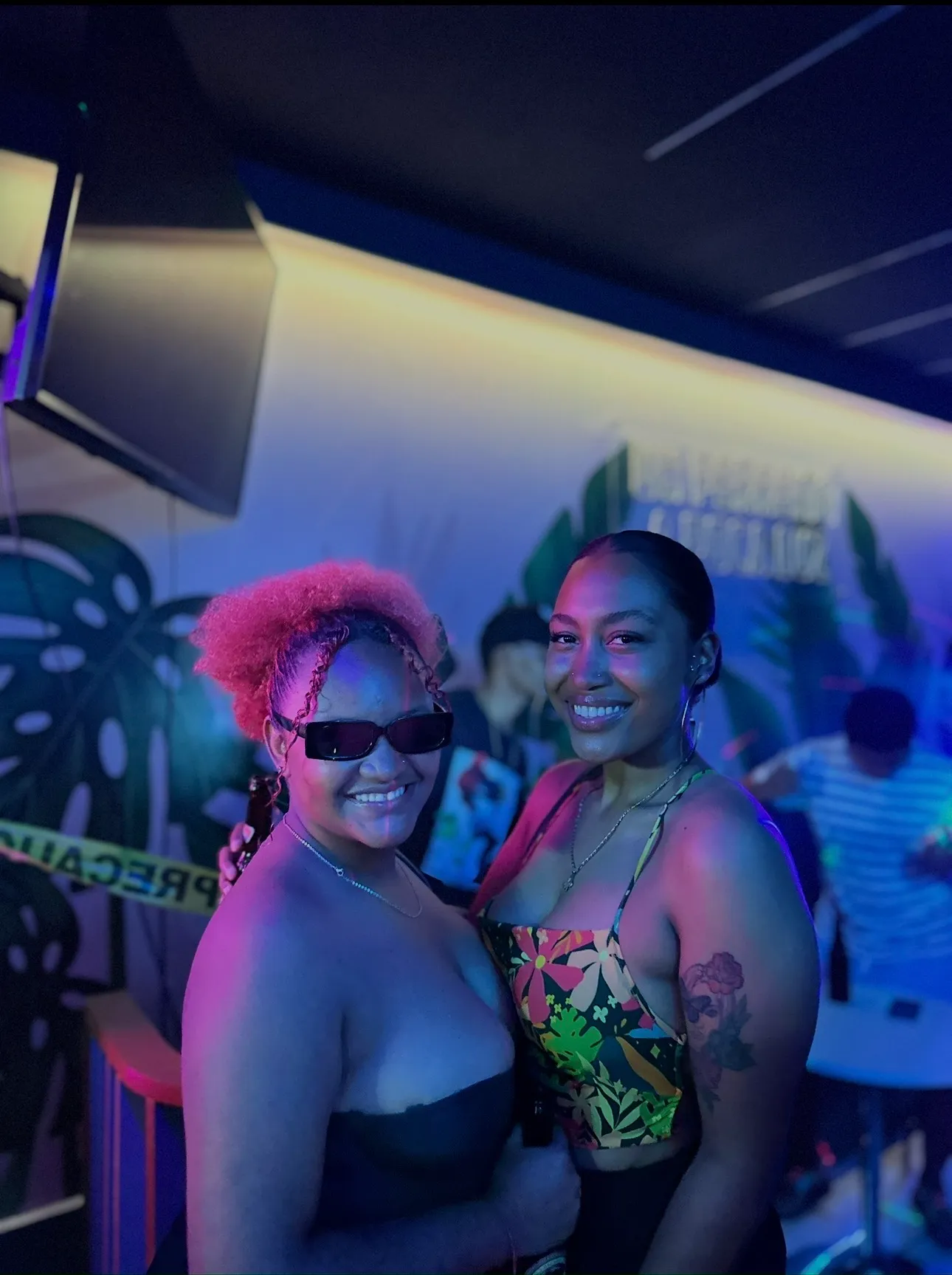 Amigas posando frente al mural del bar