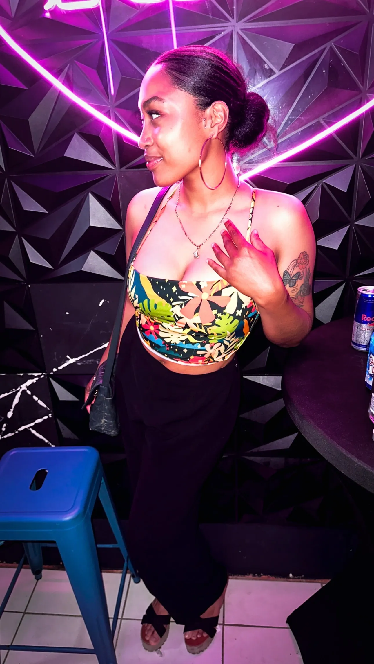 Clienta posando junto a pared geométrica con neon