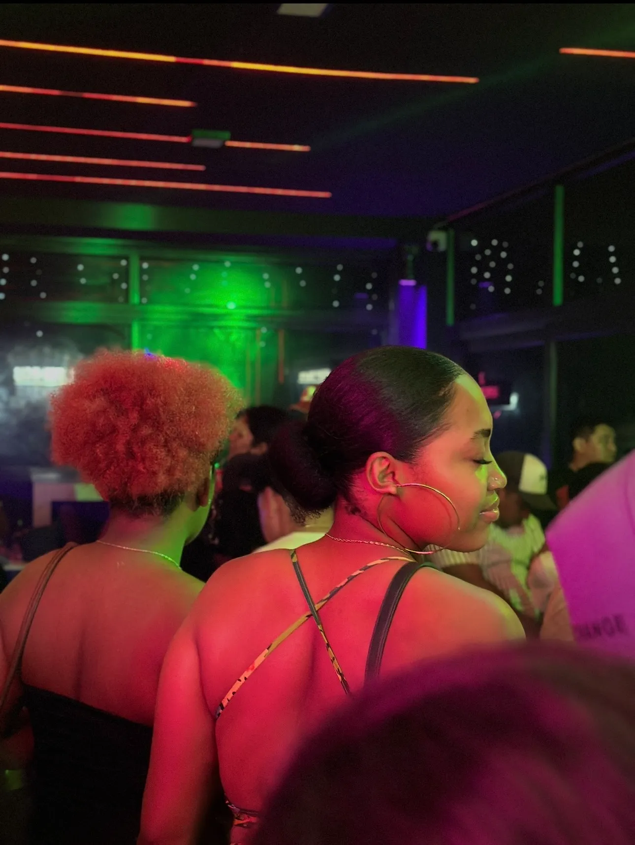 Cliente disfrutando en el bar con luces neon verdes