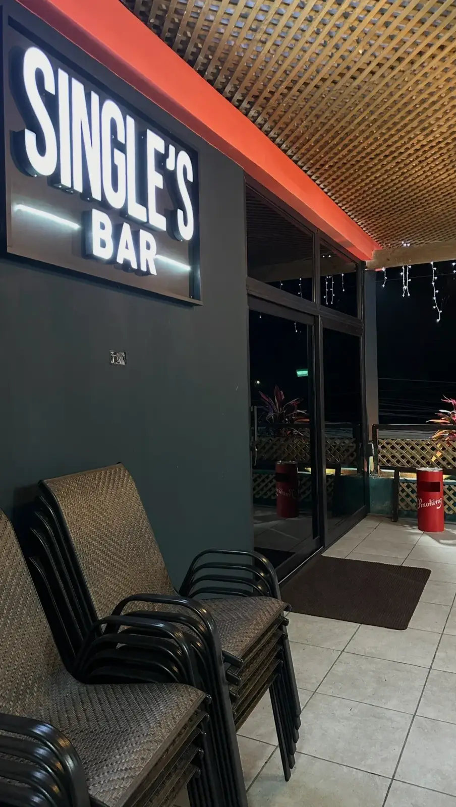 Exterior real de Single's Bar durante la noche