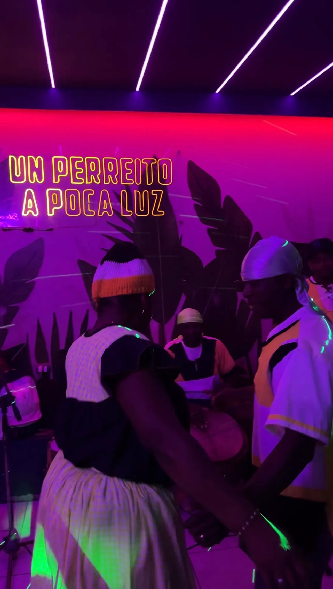 Gente bailando con neon Un Perreito a Poca Luz