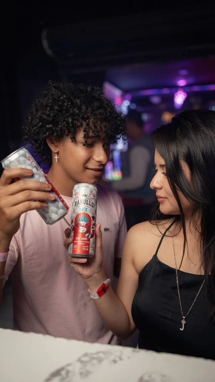 Pareja con latas Barullo Mix Spicy Sangria en la barra de Single's Bar